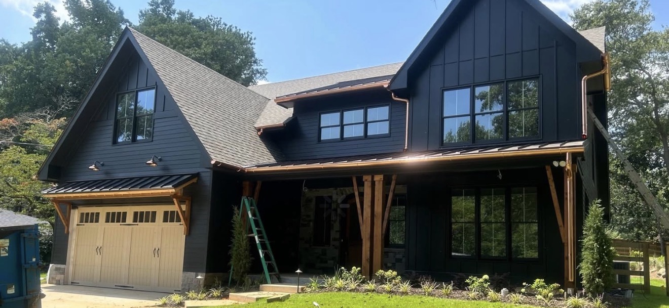 Black modern farmhouse with copper gutters, aluminum board-and-batten siding, and new roof by Hometown Exteriors and Roofing